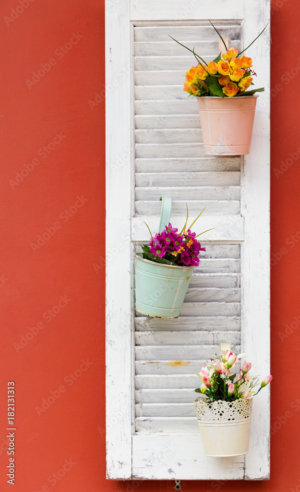 Fototapeta premium Flower pots on white wooden window on an orange wall