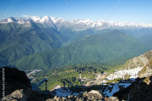 a green carpet of plants covers the slopes of mountains