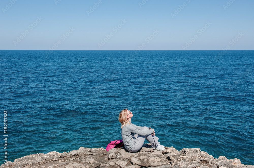 Woman tourist in Polignano, Apulia, Italy, in a summer day