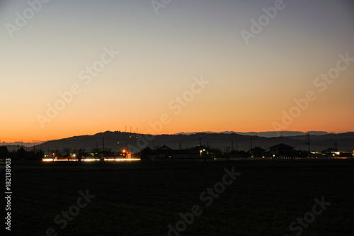 夕暮れの山と田舎と車の光 © Kana Design Image