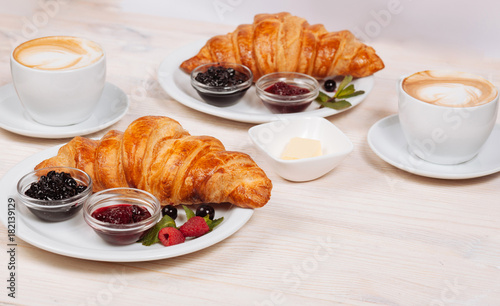Close up of fresh croissants served with fresh coffee