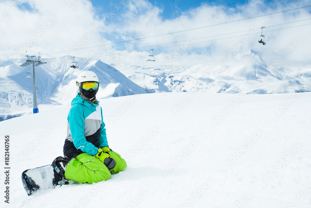 Snowboarder woman on background landscape of snowy high mountains