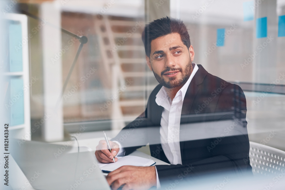 Fototapeta premium Inspired businessman looking through office window while brainstorming by workplace