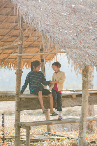 Young two sisters living and happy on thai cabin style. Asian girl play on cabin in country.