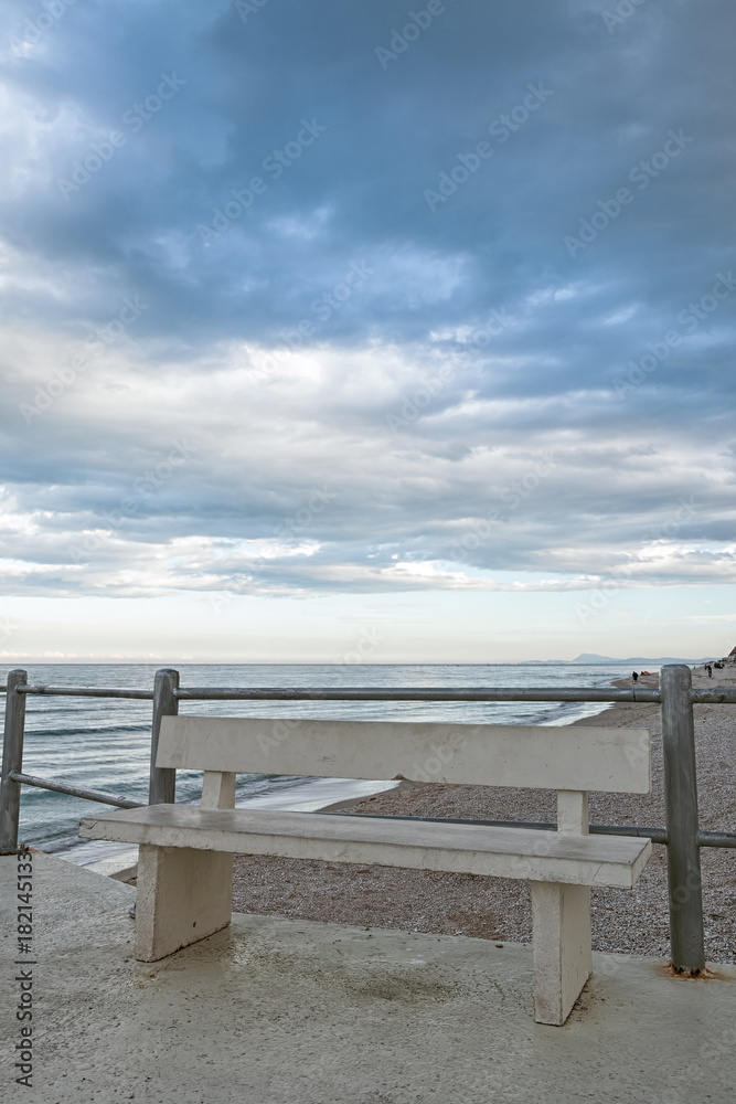 The viewpoint on the beach with bench of Marotta under a cloudy sky, Italy