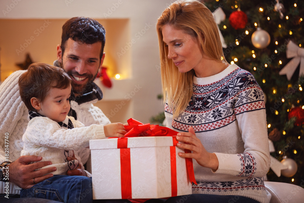 happy family celebrating Christmas at home. father and mother give a child present. happy family celebrating Christmas at home. father and mother give a child present.