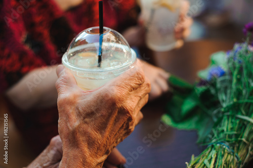 Happy elderly couple in love drinking lemonade in a cafe on the street