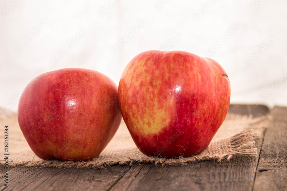 Tasty, juicy, ripe, red apples on a rustic background on a wooden table and a white background. Tasty, juicy, ripe, red apples on a rustic background on a wooden table and a white background.