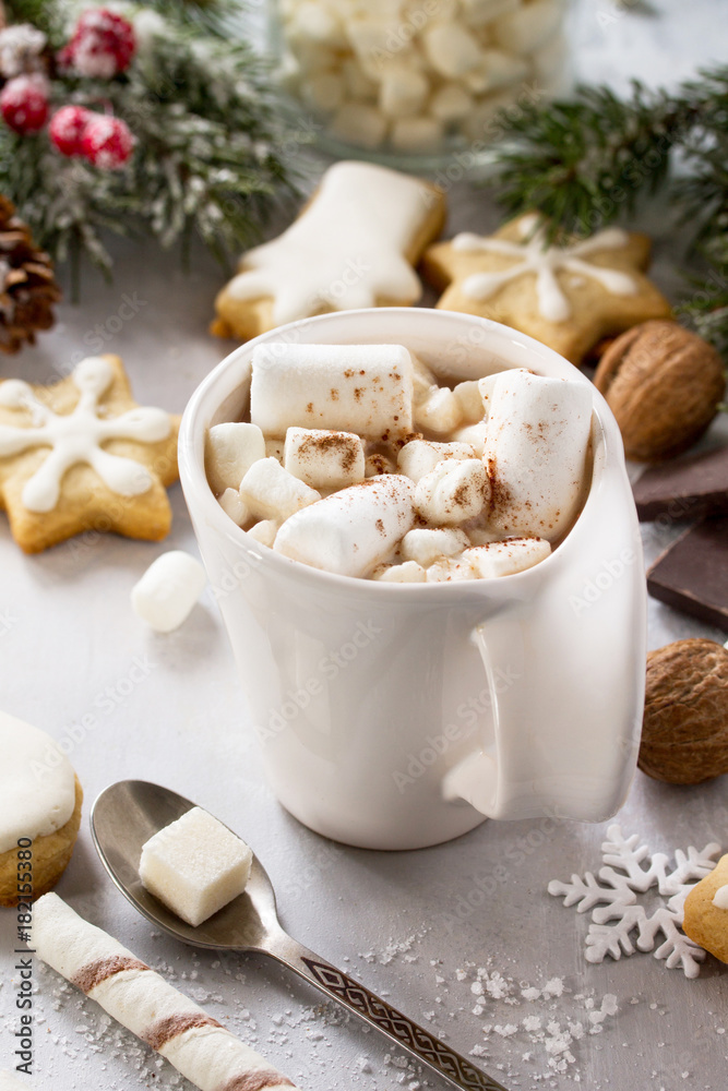 A cup of hot chocolate with marshmallows and gingerbread on a Christmas table. A cup of hot chocolate with marshmallows and gingerbread on a Christmas table.