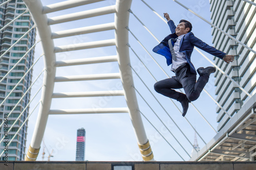 lifestyle business man feel happy jumping in air celebrating success and achievement on business district , business concept