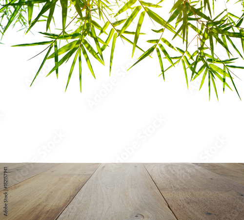 wooden table top with green bamboo leaves isolated on white background