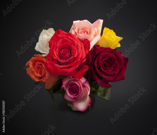 Bouquet of colorful roses on black background  top view