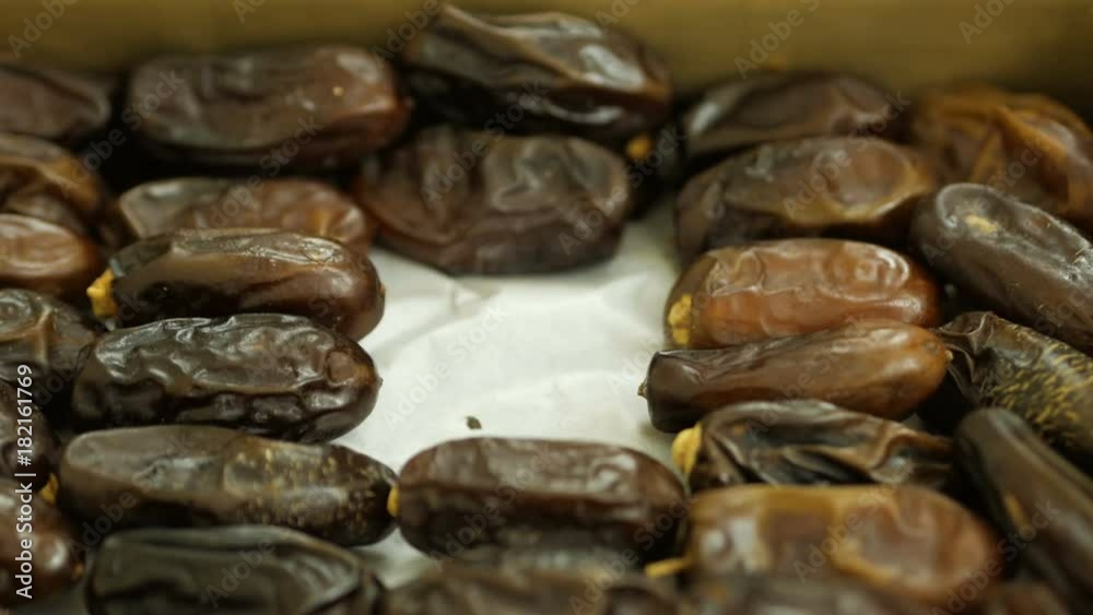 Hand folding out dates fruit in the package. People putting dates out of carton. Hand folding out dates fruit in the package. People putting dates out of carton.