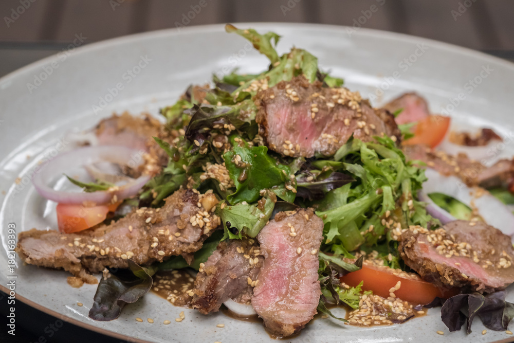 Close up Roasted beef with herbed bread crust sliced and vegetable. (selective focus)