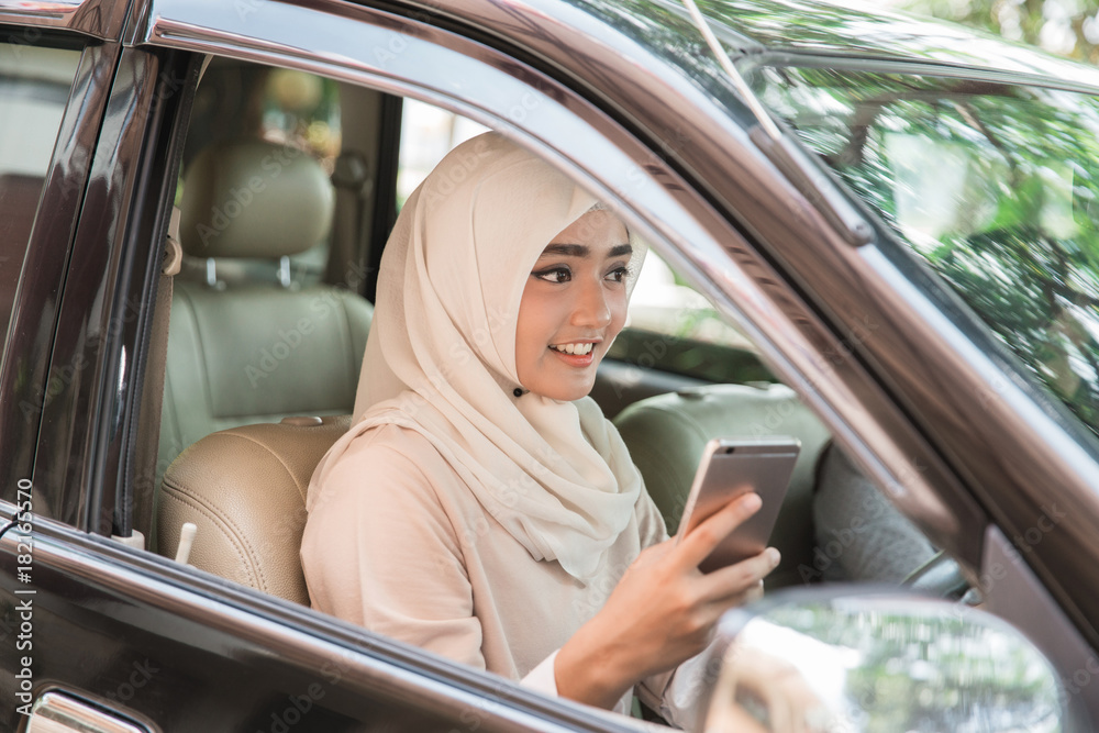 Young woman driving her car using mobile phone