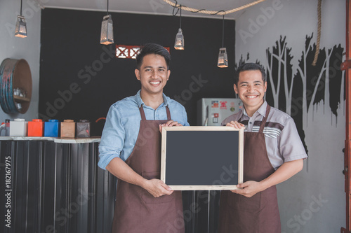 two waiter holding blank blackboard