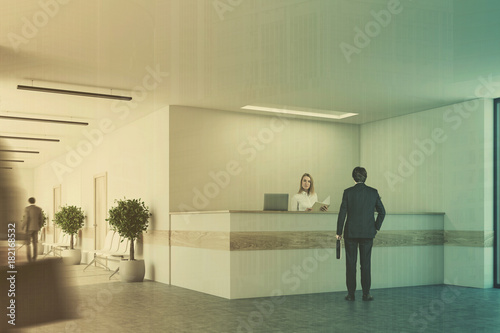 White and light wooden reception side people © ImageFlow