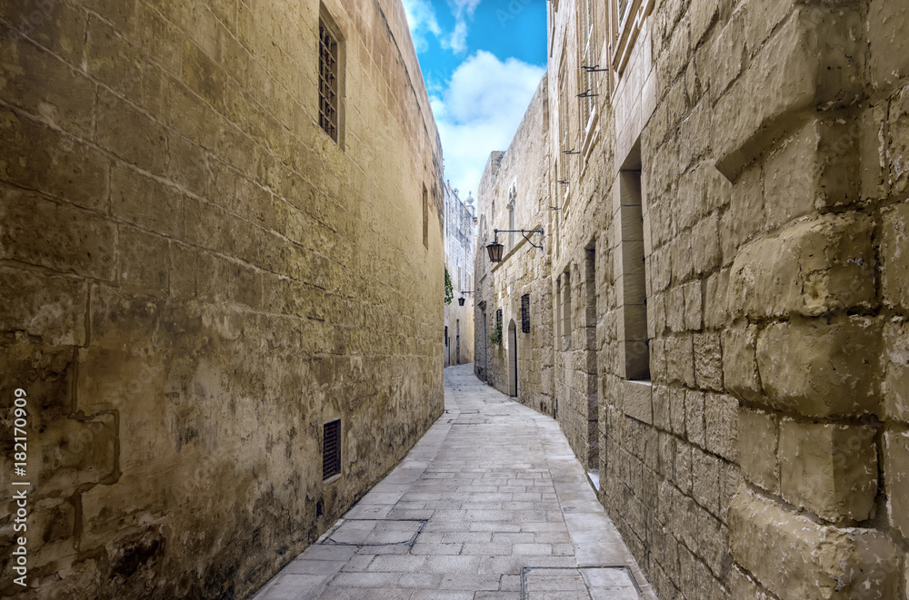beautiful view of ancient bleak narrow medieval street in town Mdina, Malta, toned style