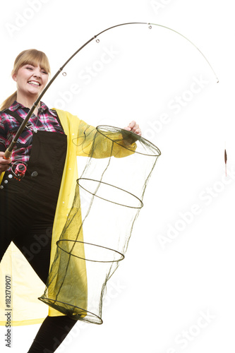 Happy woman holding fishing rod and keepnet photo