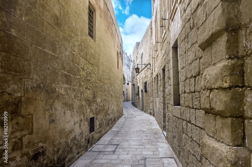 beautiful view of ancient bleak narrow medieval street in town Mdina, Malta, toned style