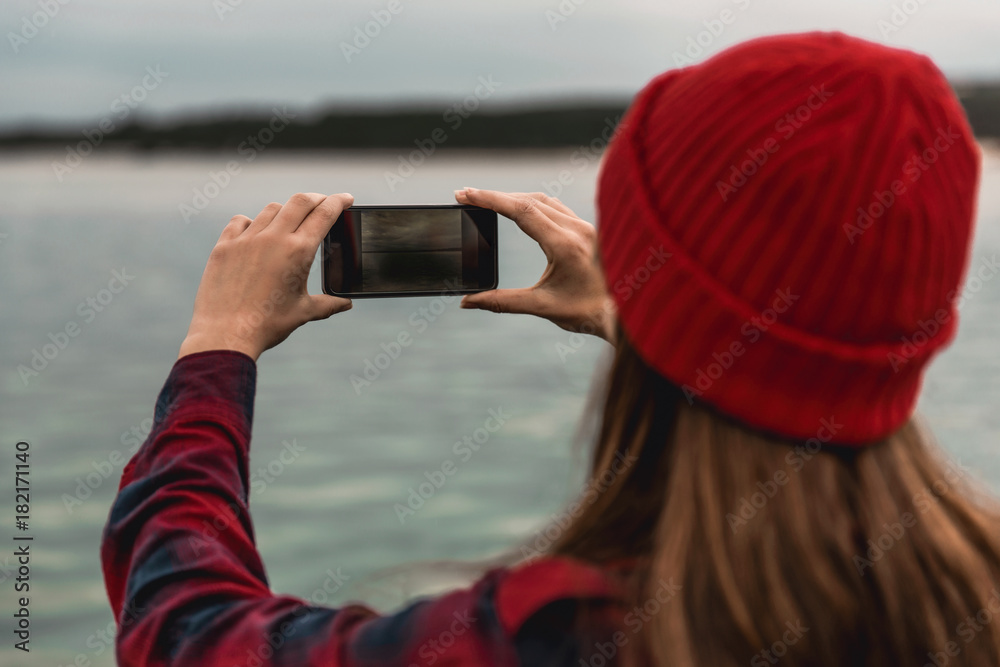 Obraz premium Woman taking pictures with a cellphone