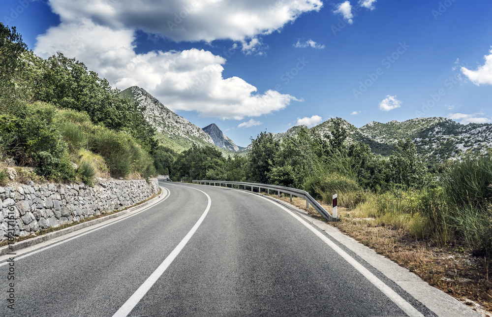 Country road through the rocky mountains and forest.