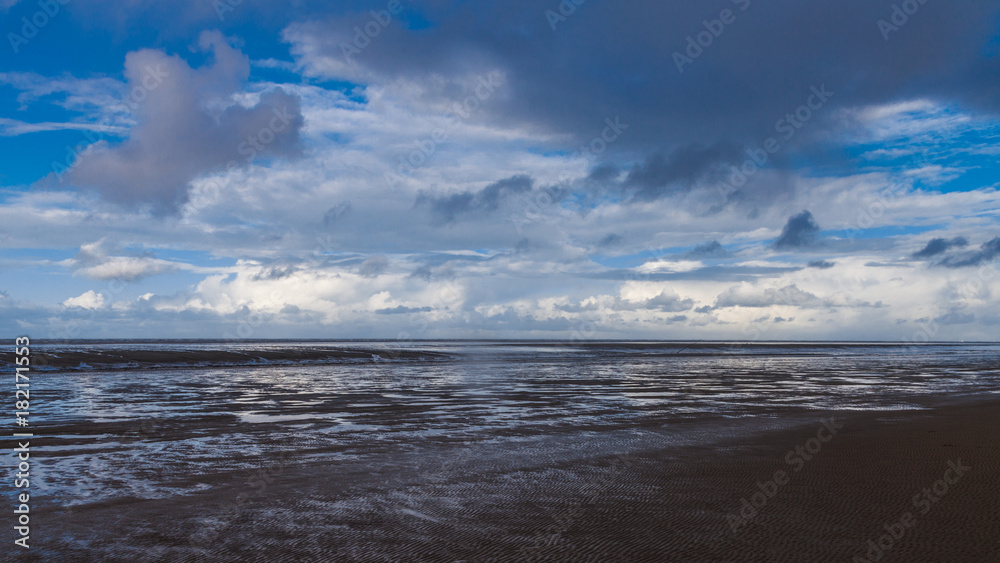 Obraz premium Wolkenformationen über dem Wattenmeer