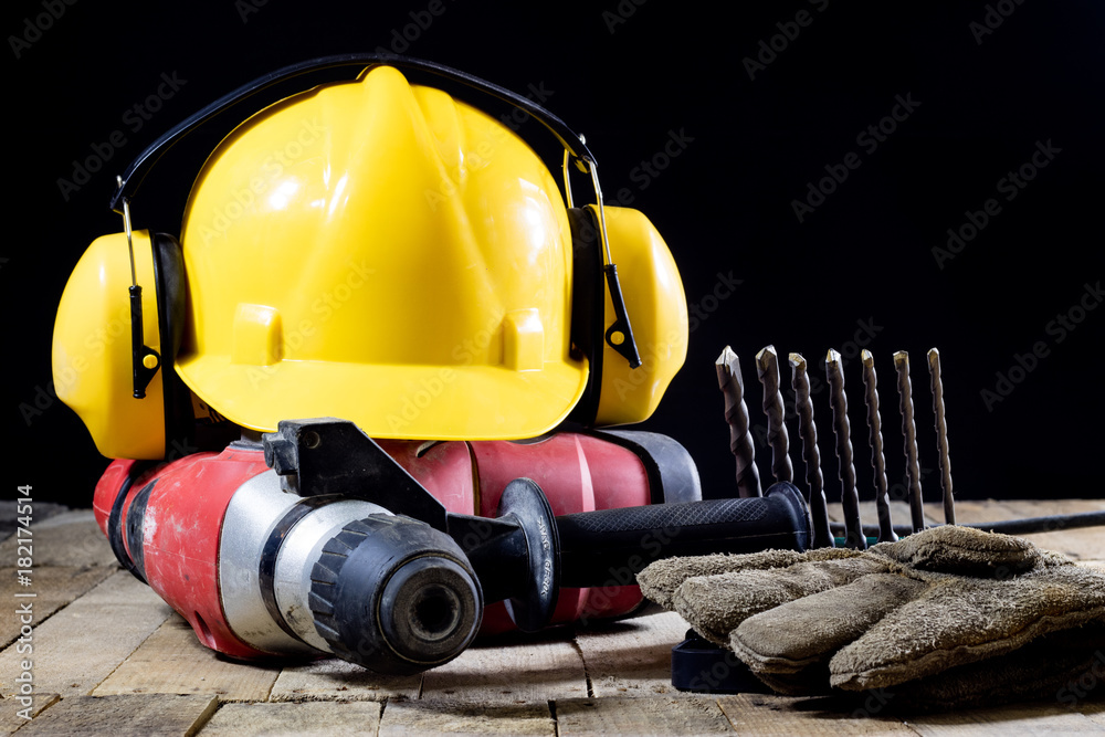 Safety accessories and impact hammer. Accessories for a builder on a wooden table. Safety accessories and impact hammer. Accessories for a builder on a wooden table.