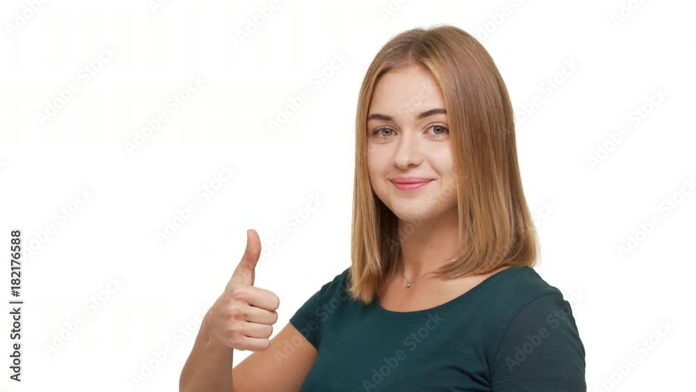 Half-turned portrait of confident female adult 20s in casual looking on camera with thumb up showing like symbol smiling over white background. Concept of emotions Half-turned portrait of confident female adult 20s in casual looking on camera with thumb up showing like symbol smiling over white background. Concept of emotions