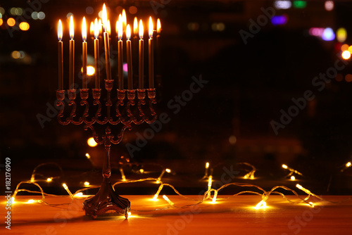 image of jewish holiday Hanukkah background with menorah (traditional candelabra) and burning candles photo