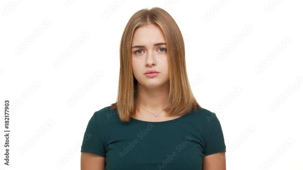 Portrait of woman with confident facial expression looking on camera with strict gaze holding index finger on lips asking to keep silence over white background. Concept of emotions Portrait of woman with confident facial expression looking on camera with strict gaze holding index finger on lips asking to keep silence over white background. Concept of emotions