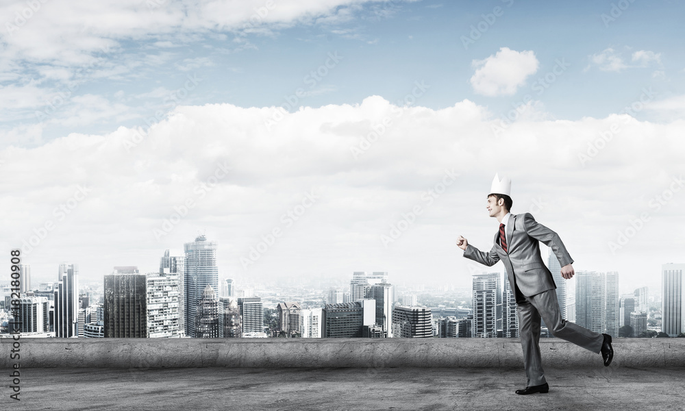 King businessman in elegant suit running on building roof and bu King businessman in elegant suit running on building roof and bu