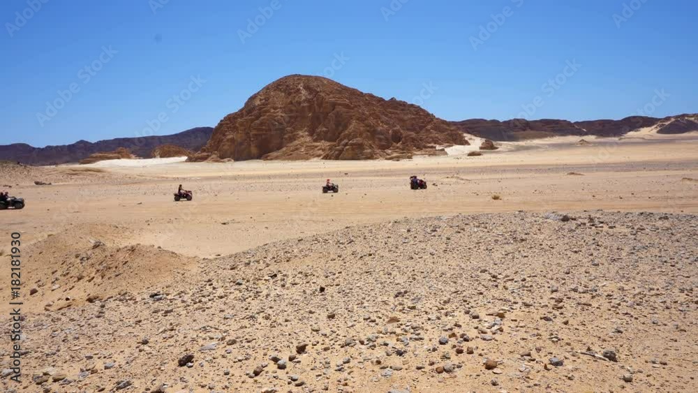 Skyline Aerial view of young men riding quad bikes over sand dunes in desert. The race in difficult conditions on the sand on a quad bike Skyline Aerial view of young men riding quad bikes over sand dunes in desert. The race in difficult conditions on the sand on a quad bike
