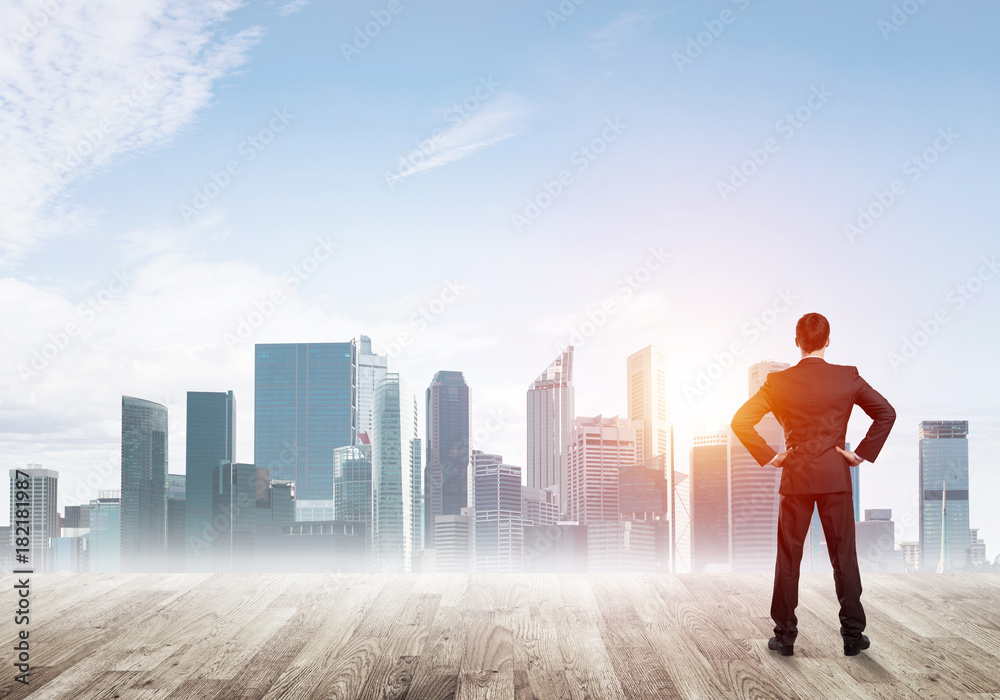 Motivation and inspiration concept with modern cityscape and businessman observing it