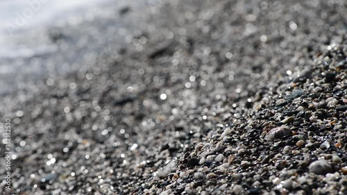 onda si infrange sulla spiaggia in una giornata estiva photo