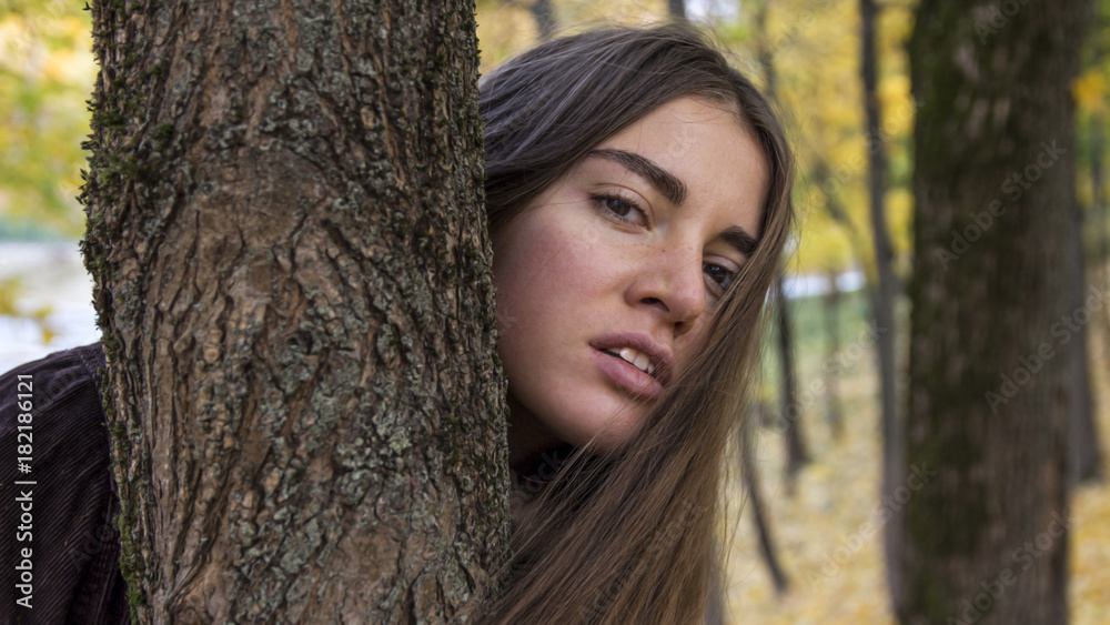 Beautiful young girl with long hair near a tree Beautiful young girl with long hair near a tree