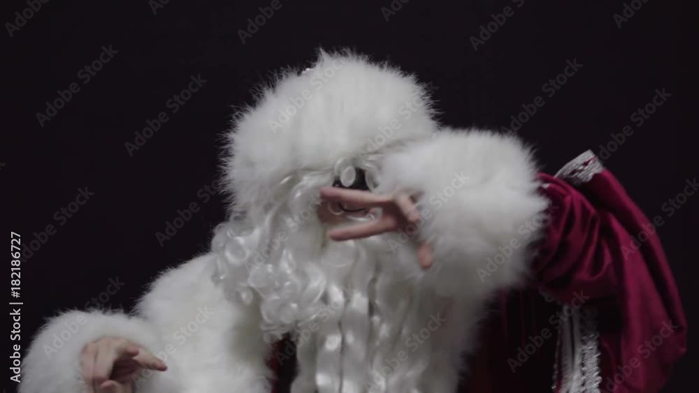 Cheerful Santa Claus dancing against black background Cheerful Santa Claus dancing against black background