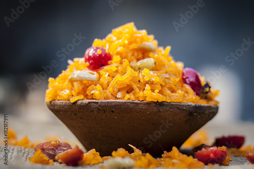 Indian sweet rice dish in a clay bowl on gunny background. photo