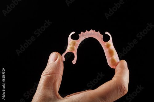 Dental prosthesis in the hand of the dentist.