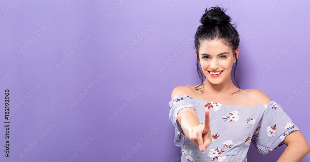 Young woman pointing at something on a solid background Young woman pointing at something on a solid background