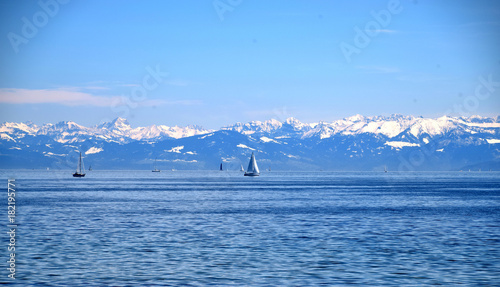 Ships on blue lake, clear blue sky, and snowy mountains, Boden Lake and Schwitzer Alps, view from Insel Mainau on spring