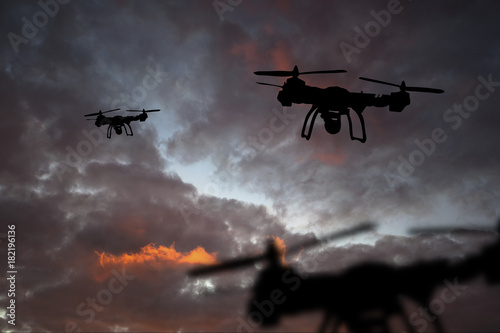 Innovation concept. Silhouette of drone flying on sunset. Heavy lift drone photographing