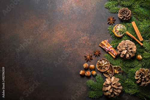 Christmas spices and nuts on dark stone table. Top view copy space.