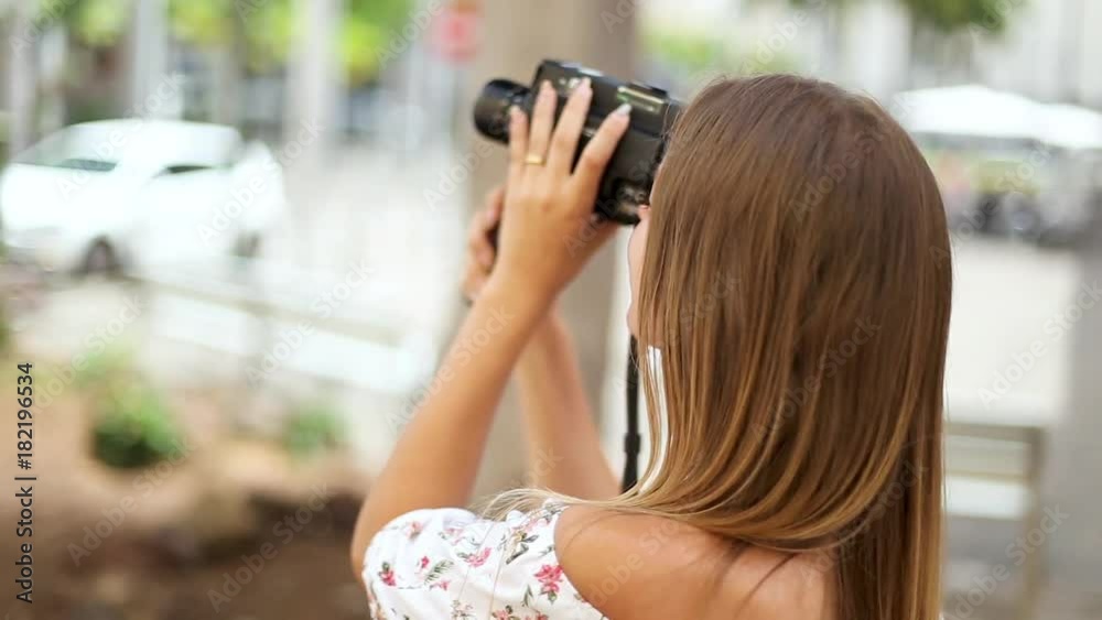 Cute blonde tourist girl is filming streets and sightseeing in Santa Cruz de Tenerife, Canary Islands, Spain. The girl travels concept. Cute blonde tourist girl is filming streets and sightseeing in Santa Cruz de Tenerife, Canary Islands, Spain. The girl travels concept.