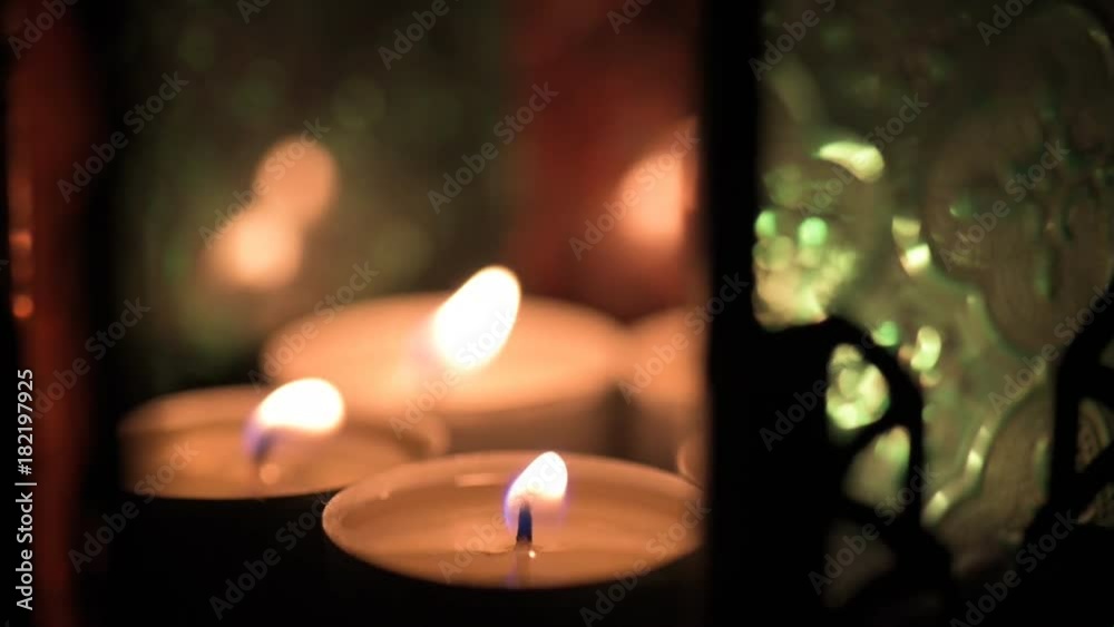 Coloured glass in a lantern lit by tea light candles with door open. Coloured glass in a lantern lit by tea light candles with door open.