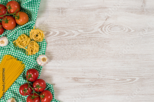 Italian pasta raw ingredients on wooden background.
