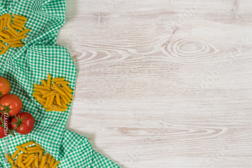 Italian pasta raw ingredients on wooden background.