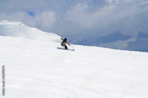 the skier descends from the slope in the clouds