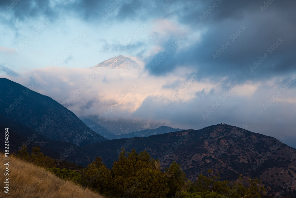 Clouds hang over mountains.