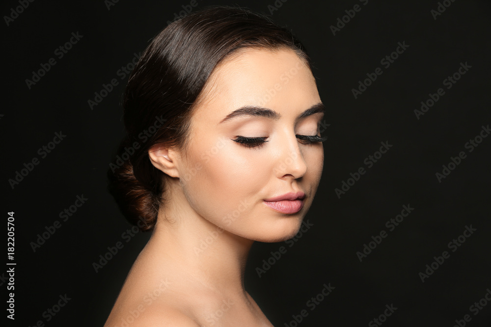 Beautiful young woman with eyelash extensions on dark background Beautiful young woman with eyelash extensions on dark background